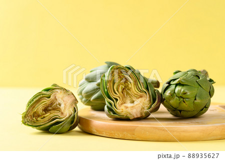 Half green artichoke on yellow background, Edible flower bud Half green artichoke on yellow background, Edible flower bud 88935627
