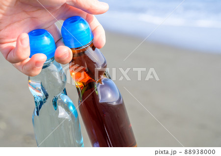 海で手に持った瓶ジュース 海で手に持った瓶ジュース 88938000