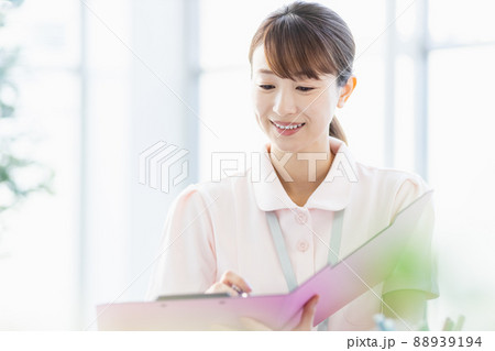 施設内でファイルに記入している医療従事者の女性 88939194