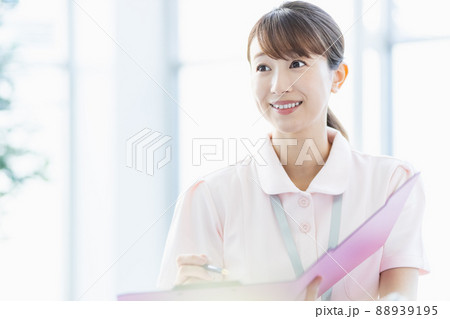 施設内でファイルに記入している医療従事者の女性 88939195