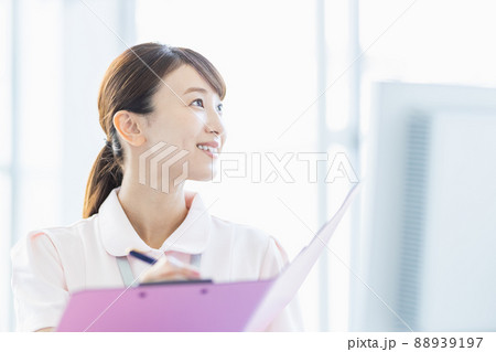施設内でファイルに記入している医療従事者の女性 88939197