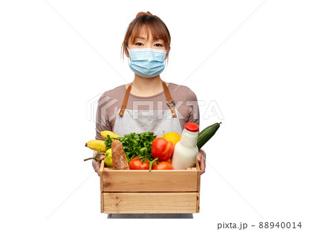 female chef in mask with food in wooden box 88940014