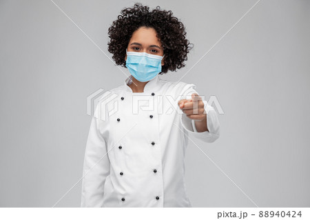 female chef in medical mask pointing to camera 88940424