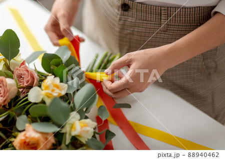 close up of woman making bunch of flowers on table close up of woman making bunch of flowers on table 88940462