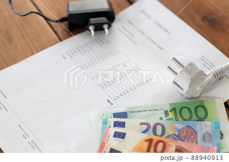 utility bill, money and electric plugs on table 88940913