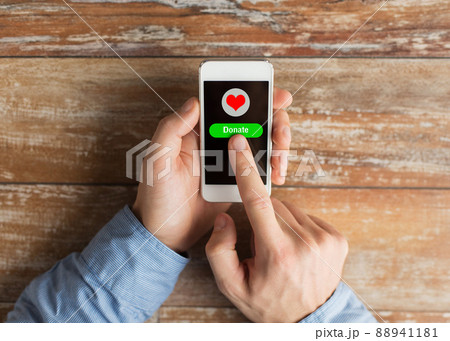 close up of hands with donate icon on smartphone 88941181