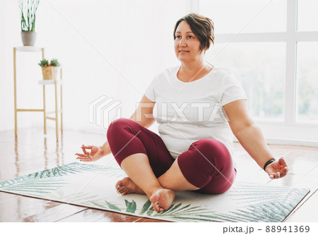 Adult charming brunette woman plus size body positive practice yoga at the bright studio Adult charming brunette woman plus size body positive practice yoga at the bright studio 88941369