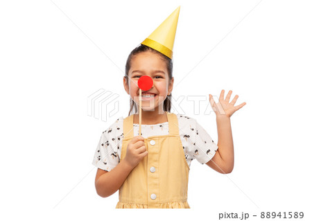 girl in birthday party hat with red clown nose 88941589