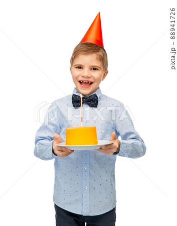 smiling boy in party hat with birthday cake smiling boy in party hat with birthday cake 88941726