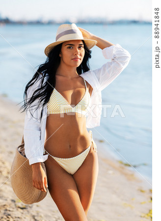 happy woman in bikini and shirt walking on beach happy woman in bikini and shirt walking on beach 88941848