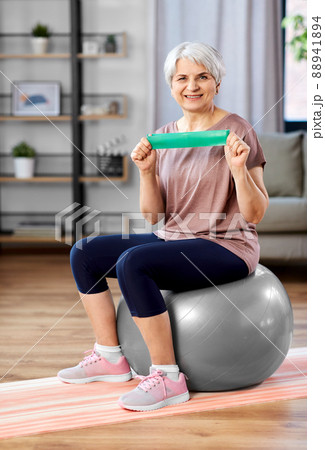 senior woman exercising with elastic band at home senior woman exercising with elastic band at home 88941894