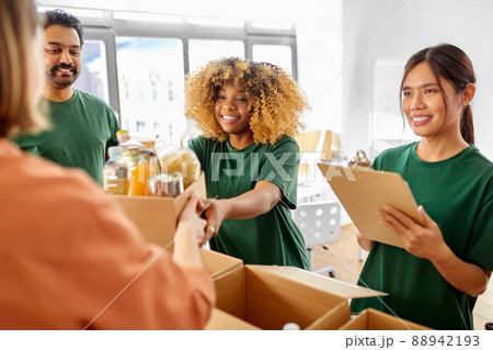 happy volunteers packing food in donation boxes 88942193