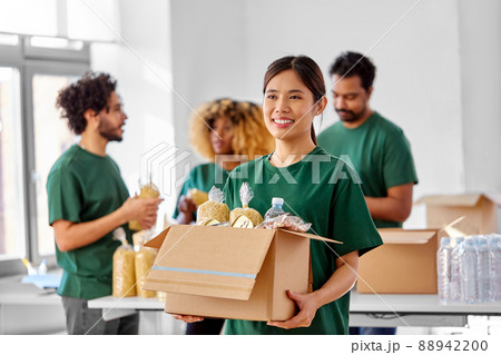 happy volunteers packing food in donation boxes happy volunteers packing food in donation boxes 88942200