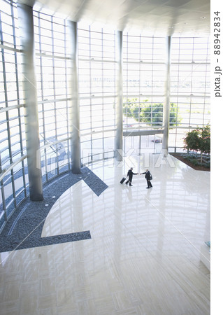 Business people shaking hands in modern lobby 88942834
