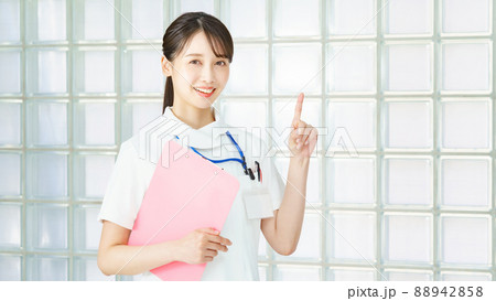 指を立てるポーズをする白衣の女性  88942858