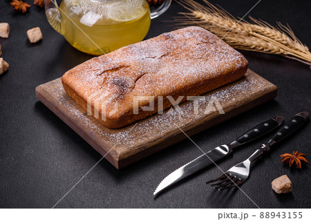 Baked rectangular cupcake with raisins and chocolate on a dark concrete background Baked rectangular cupcake with raisins and chocolate on a dark concrete background 88943155