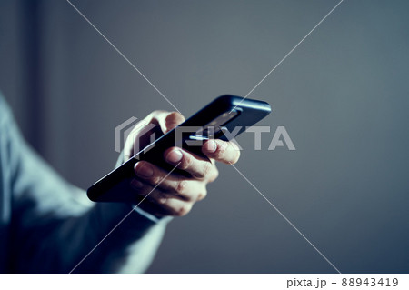 SNSで悪評を広める男性の手元 88943419