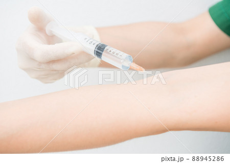 Cropped shot view of someone injecting themself with a syringe into a vein on the arm. Syringes are used for putting liquids into things. Cropped shot view of someone injecting themself with a syringe into a vein on the arm. Syringes are used for putting liquids into things. 88945286