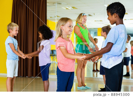 Group of children practicing vigorous jive movements in dance cl 88945300