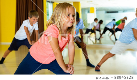 Portrait of smiling children practicing sport dance in modern dance hall Portrait of smiling children practicing sport dance in modern dance hall 88945328