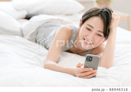 女性　ライフスタイル　ベッド　スマホ 88946318