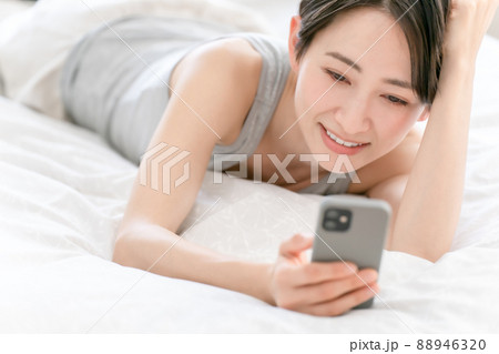 女性　ライフスタイル　ベッド　スマホ 88946320