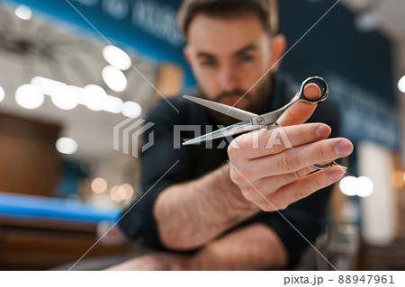 Handsome male hairdresser with scissors in hands	 88947961