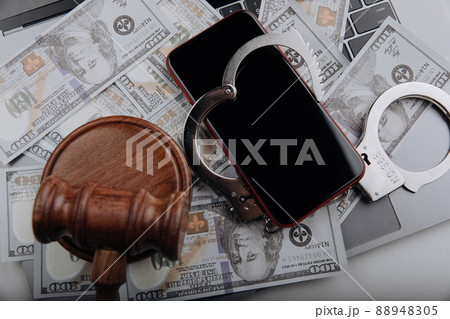 Smartphone with handcuff and judge gavel on cash. Information security and law concept 88948305