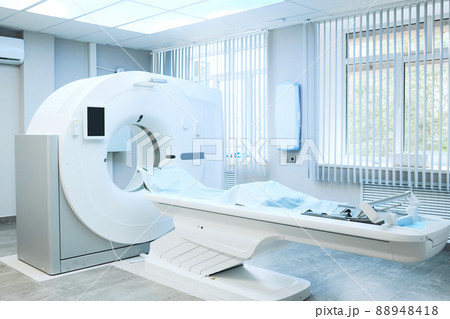 Modern large computer tomography machine with table covered with disposable sheet in hospital room Modern large computer tomography machine with table covered with disposable sheet in hospital room 88948418