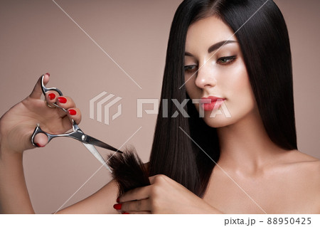 A young woman cutting her hair A young woman cutting her hair 88950425