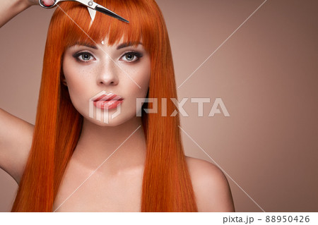 Beautiful young woman with a scissors Beautiful young woman with a scissors 88950426