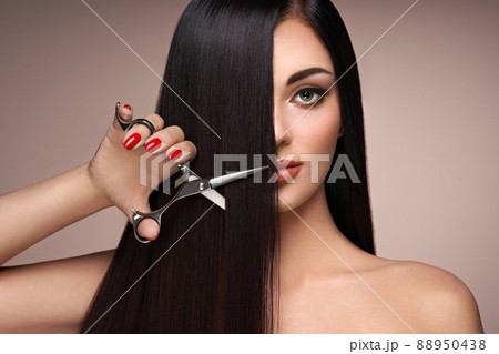 A young woman cutting her hair 88950438