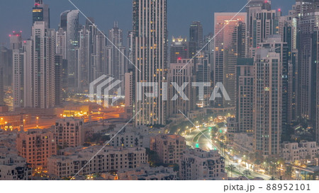Futuristic aerial cityscape night to day timelapse with illuminated architecture of Dubai downtown, United Arab Emirates. 88952101