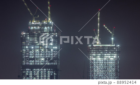 Cranes working at night on modern constraction site works of new skyscraper timelapse Cranes working at night on modern constraction site works of new skyscraper timelapse 88952414