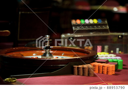 There is a red table with roulette chips in the casino 88953790