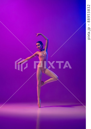 Portrait of young little ballet dancer, teen practicing, dancing isolated on purple background in neon light. Art, grace, beauty, ballet school concept Portrait of young little ballet dancer, teen practicing, dancing isolated on purple background in neon light. Art, grace, beauty, ballet school concept 88953832