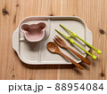 写真素材｜幼児食のエプロンと補助箸と食器のセット 子ども 88954084