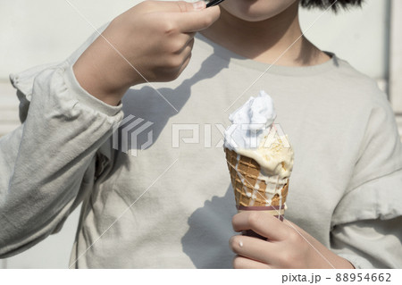 外でアイスクリームを食べる女の子 88954662