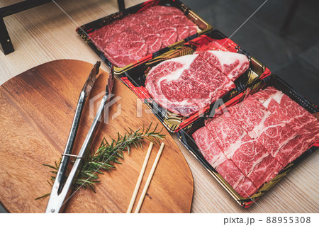 Meat tongs on a cutting board with Sliced fresh meat for steaks or barbecue grilled party at home. Meat tongs on a cutting board with Sliced fresh meat for steaks or barbecue grilled party at home. 88955308