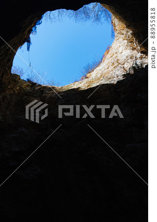 view from the cave to the blue sky. a natural well on slope of Mount. view from the cave to the blue sky. a natural well on slope of Mount. 88955818