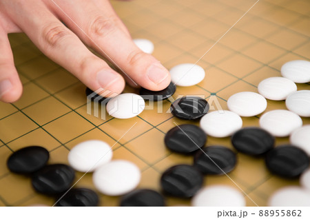 囲碁で黒石を打つ手元 88955862