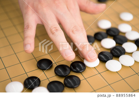 囲碁で白石を打つ手元 88955864
