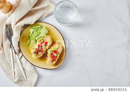 Crostini or bruschetta with softened avocado, ham and tomatoes. Toast with mashed avocado 88959333