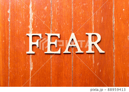 Alphabet letter in word fear on old red color wood plate background 88959413