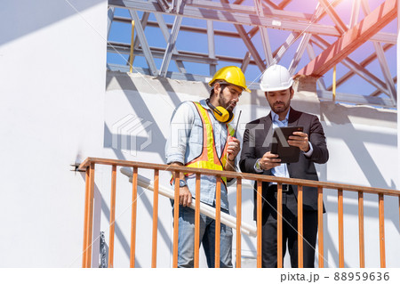Architect and developer with blueprints discussing architect project at construction site. Architect and developer with blueprints discussing architect project at construction site. 88959636