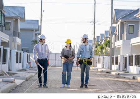Engineer and architect discussing building plan at construction site. 88959758