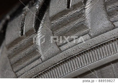 Old worn black tire with many large cracks in the car wheel. 88959827