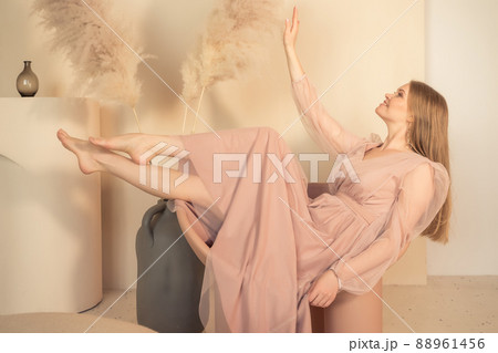girl in pastel-colored dress sits on chair with her legs up girl in pastel-colored dress sits on chair with her legs up 88961456