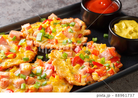 Fritters with corn, ham pepper and onion served with sauces close-up on a plate. horizontal 88961737