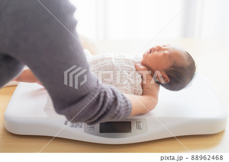 体重を測る新生児　母測　生後9日 88962468